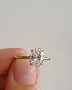 a person holding a diamond ring in their hand