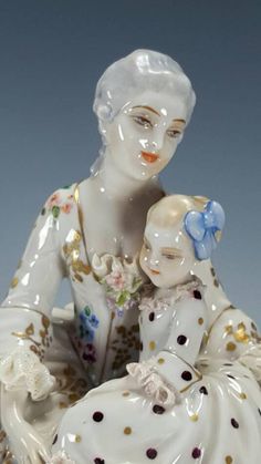 a porcelain figurine of a woman holding a baby