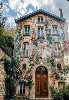 a large building with flowers painted on it's side and windows above the door