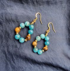 Hanging earring in golden stainless steel, handmade in natural blue apatite stone and tiger's eye, ideal for a gift Each piece is carefully prepared and packed in a pretty purse Many other models available in the shop 🌺 You can find me on my Instagram account: @ellastonecreation Amazonite Drop Earrings As Gift, Blue Amazonite Jewelry With Natural Stones, Dangle Earrings With Amazonite And Natural Stones, Spiritual Handmade Agate Earrings, Spiritual Agate Gemstone Earrings, Turquoise Apatite Gemstone Earrings, Amazonite Natural Stone Earrings For Gifts, Blue Apatite Gemstone Earrings, Spiritual Agate Earrings With Natural Stones