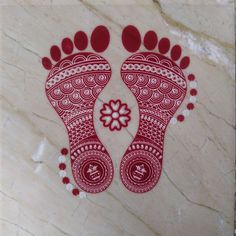 a pair of feet with red and white designs on the floor in front of a marble wall