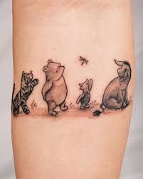 a small tattoo of winnie the pooh and her friends