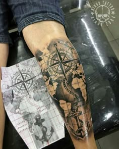 a man's arm with a compass tattoo on it and a map in the background