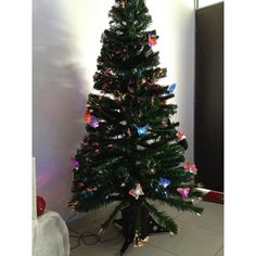 a decorated christmas tree in the corner of a room with white walls and flooring