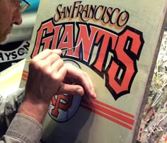 a man is painting the san francisco giants logo