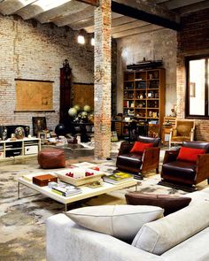 a living room filled with lots of furniture and decor on top of a stone floor