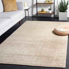 a living room with a white couch and rug on the floor next to a coffee table