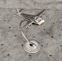 a metal model of an airplane on top of a table with holes in the floor