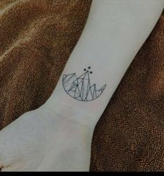 a small tattoo on the wrist of a woman's arm, with geometric shapes