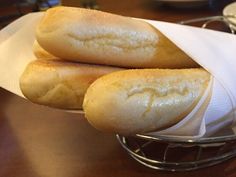 two loaves of bread sitting on top of a white paper towel in a basket