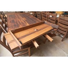 a wooden table and chairs in a room with lots of other furniture on the floor