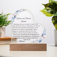 a glass plaque with a poem on it sitting on a table next to a potted plant