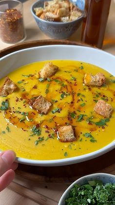 a bowl of soup with croutons and parsley