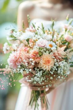 a woman holding a bouquet of flowers in her hand