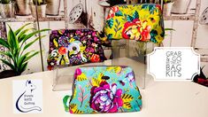 three colorful bags sitting on top of a white table next to plants and potted plants