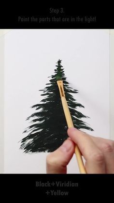 a hand holding a paintbrush next to a drawing of a pine tree with black - and - yellow tips