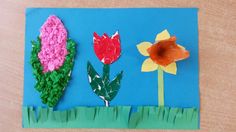 paper flowers and grass on a blue background