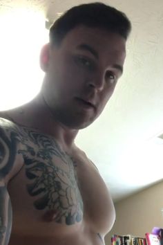 a man with tattoos on his arm and chest