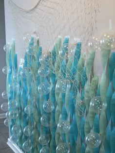 there are many blue and green vases on the wall in front of each other