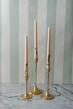 three candles sitting on top of a marble table