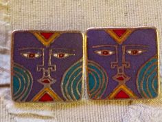 "Laurel Burch Burch KARUNA Tribal Face Cloisonne Earrings RARE Post Style Vintage Jewelry 1980s Purple Teal Red Two amazing orange-yellow, purple, and teal squares of matte brass Cloisonne. Each measure approx. 3/4\" with 14k Gold Filled posts. Named and signed on the back: Burch KARUNA Laurel Burch. A Genuine LAUREL BURCH COLLECTIBLE from the mid-1980s. This pair is in gorgeous condition, with no chips or repairs... there may be some very light, fine scratches or minimal wear around the edges. Cloisonne Earrings, Christmas Cover, Purple And Teal, Vintage Jewelry Box, Laurel Burch, Purple Teal, Cat Earrings, Gold Art, Jewelry Earrings Studs