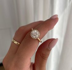 a woman's hand holding a diamond ring