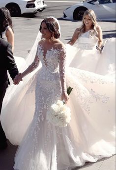 the bride and groom are walking down the street with their wedding gowns in hand