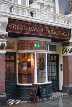 the entrance to a french horn restaurant with a sign in front of it that says green man and french horn