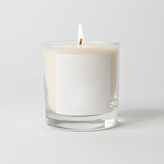 a white candle sitting inside of a glass container