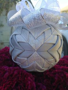 a silver ornament sitting on top of a pile of red fuzzy rugs