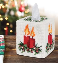 a tissue box decorated with candles and holly