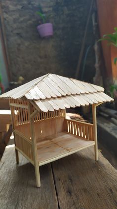 a small wooden structure sitting on top of a wooden table