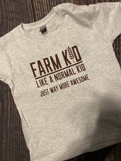 Farm Kid Graphic Tee Farm Graphic Tees, Farm T Shirts, Gray Cotton Shirt With Graphic Print, Pre-shrunk Gray Cotton Shirt, Funny Cotton Slogan Tops, Gray Pre-shrunk Graphic Tee, Gray Text Print T-shirt For Fall, Fitted Cotton Slogan Shirt, Funny Unisex Short Sleeve Shirt