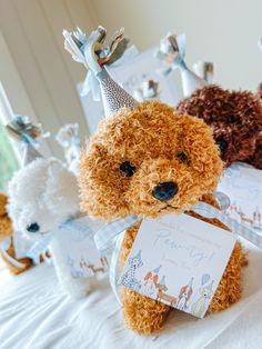 two teddy bears wearing party hats and one holding a birthday card in front of them