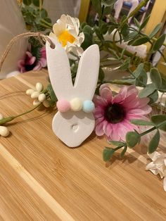 a close up of a wooden table with flowers on it and an easter bunny decoration