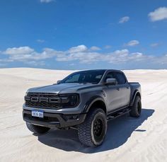 a gray truck is parked in the sand