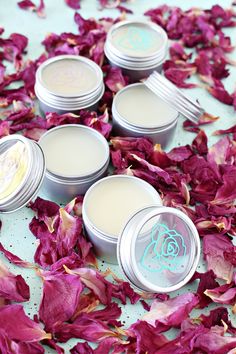 four tins filled with lip bales surrounded by petals