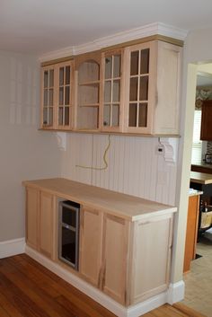 an empty kitchen with wooden cabinets and wood flooring in the middle of the room