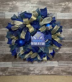 the hanukkah wreath is made with blue and gold mesh, hanging on a wooden wall