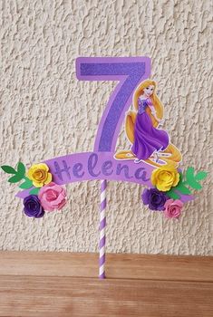 a purple cake with flowers on it and the number seven in front of her is an image of princess aurora