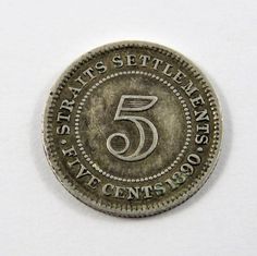 an old five cents coin with the number five on it's reverse side, sitting on a white surface