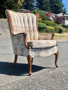 an old chair is sitting on the side of the road