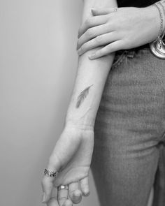 a woman's arm with an arrow tattoo on it