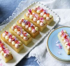 there are many small desserts on the plate and one is decorated with pink flowers