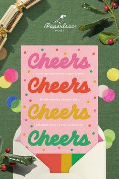 an open envelope with the words cheers cheers on it next to christmas decorations and greenery