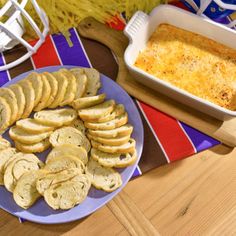 a plate with crackers on it next to a casserole dish