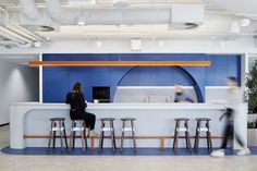 two people sitting at a bar in an office with blue walls and white counter tops