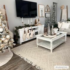 a living room decorated for christmas with white furniture