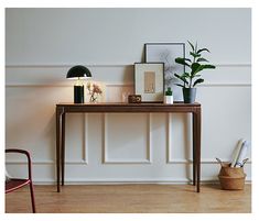 a table with some plants and pictures on it next to a chair in a room