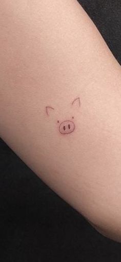 a small pig tattoo on the right arm and leg, which is drawn in pink ink